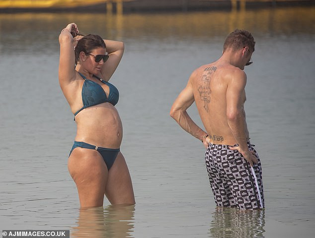 Rebekah Vardy flaunts her blossoming bump as she kisses her husband Jamie Vardy in the sea in Dubai (Photos)