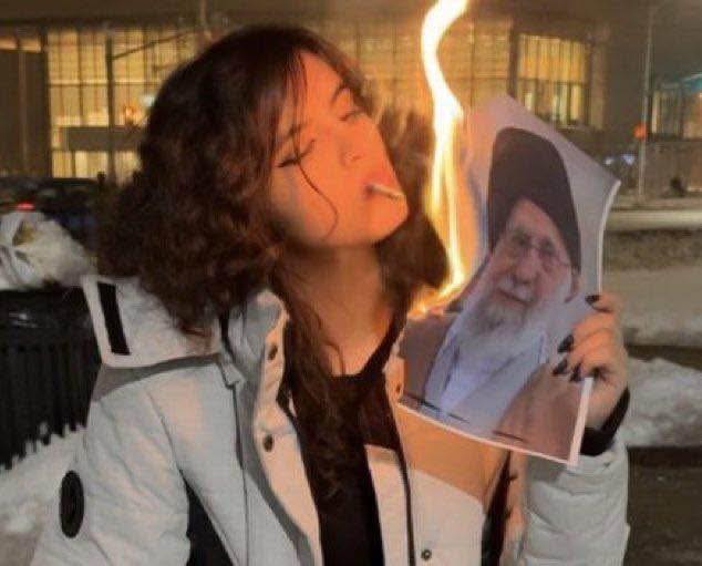 Iranian women light cigarettes with burning photo of their countryâ€™s supreme leader