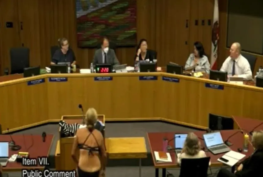 Shocking moment mum strips during school board meeting to protest transgender�students using girls